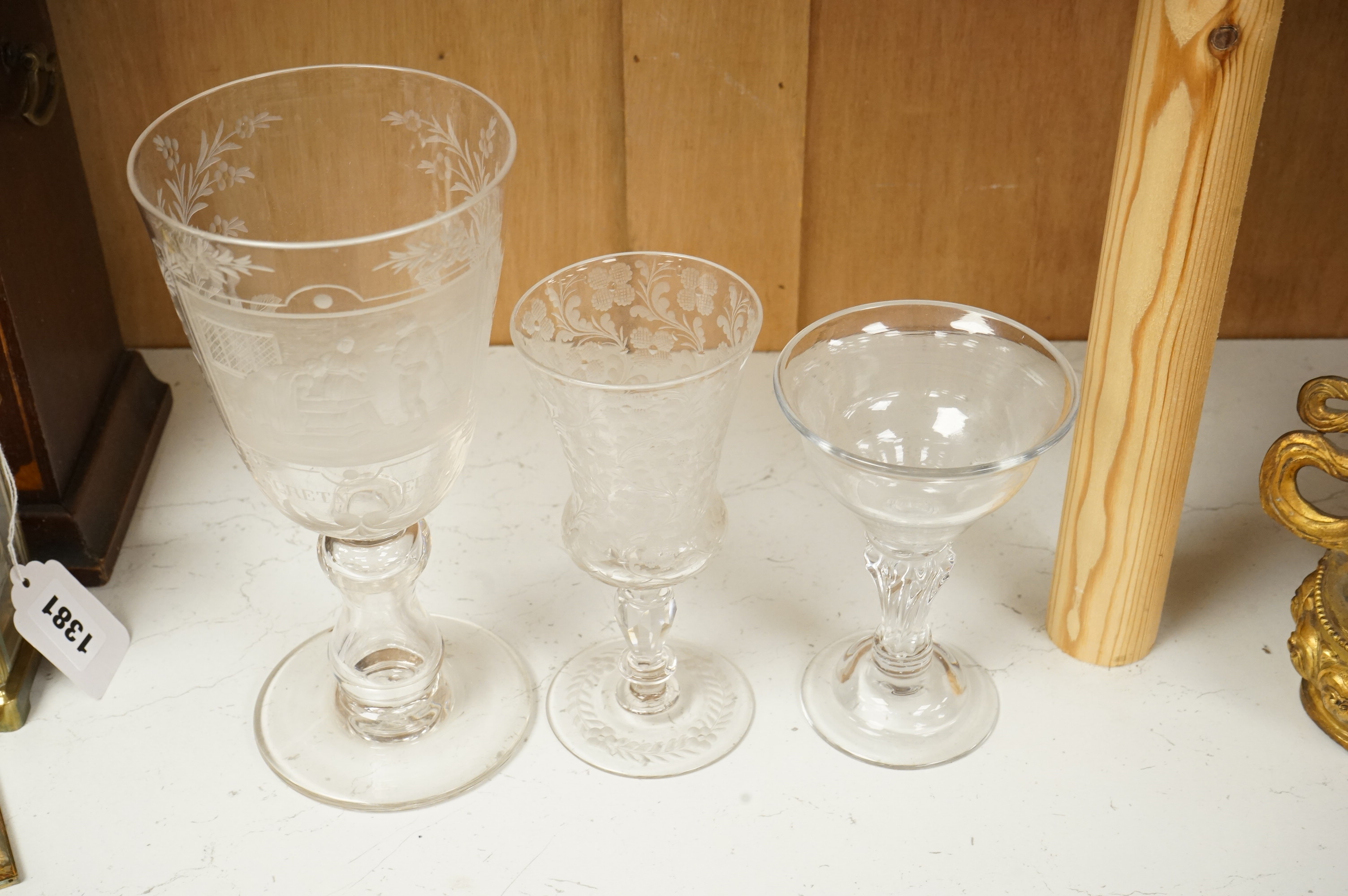 An 18th century sweetmeat glass, a 19th century large wheel engraved ‘Gretna Green’ goblet and a smaller floral engraved glass, tallest 23cm